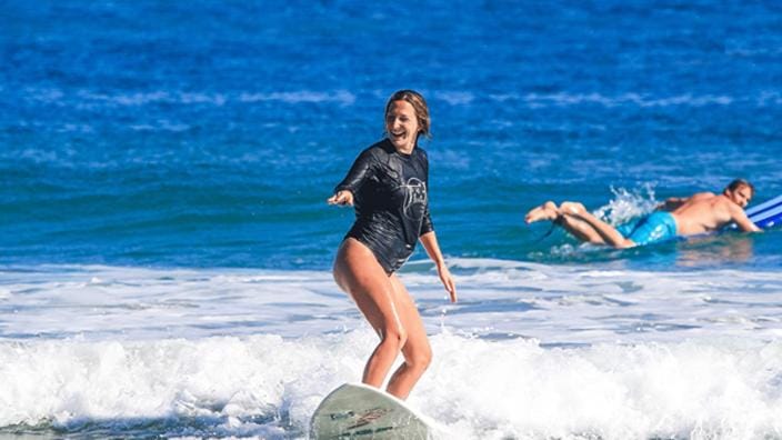 A young girl learning how to surf at Carolina School of Surf